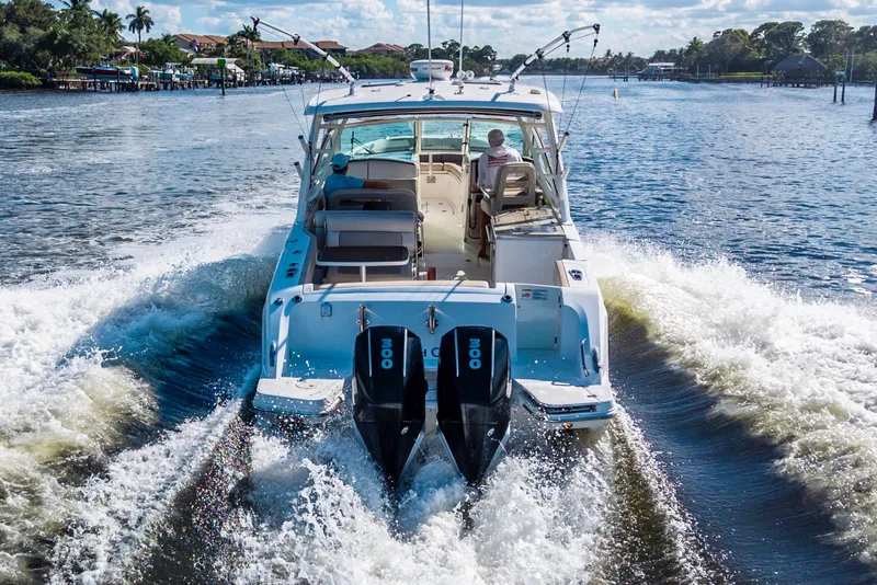 Slide: The Image of 2019 Boston Whaler 320 Vantage cruising on a scenic waterway. - 6