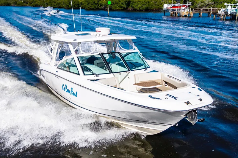 Slide: The Image of 2019 Boston Whaler 320 Vantage cruising on a scenic waterway. - 9