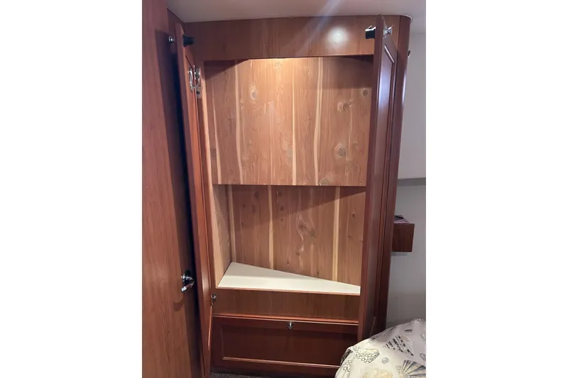 Slide: The Image of Wooden cabinet interior on 2008 Mainship 34 Trawler, featuring shelves and storage space. - 12