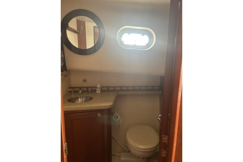 Slide: The Image of 2008 Mainship 34 Trawler bathroom with round mirror, sink, and porthole window. - 17