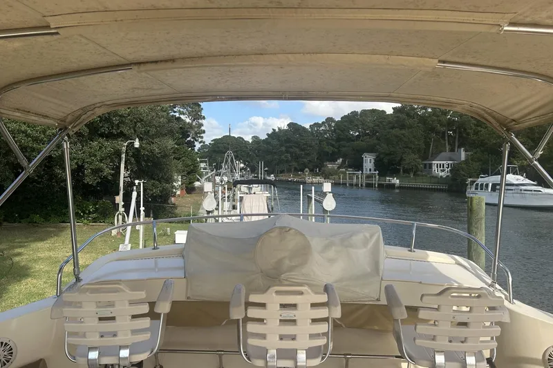 Slide: The Image of 2008 Mainship 34 Trawler docked by a scenic riverside with lush greenery. - 19