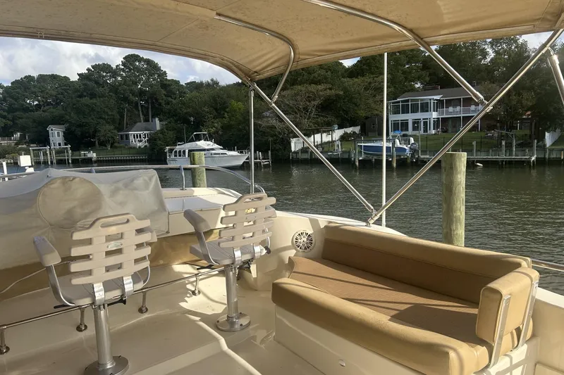 Slide: The Image of 2008 Mainship 34 Trawler interior with seating, docked near waterfront homes. - 20