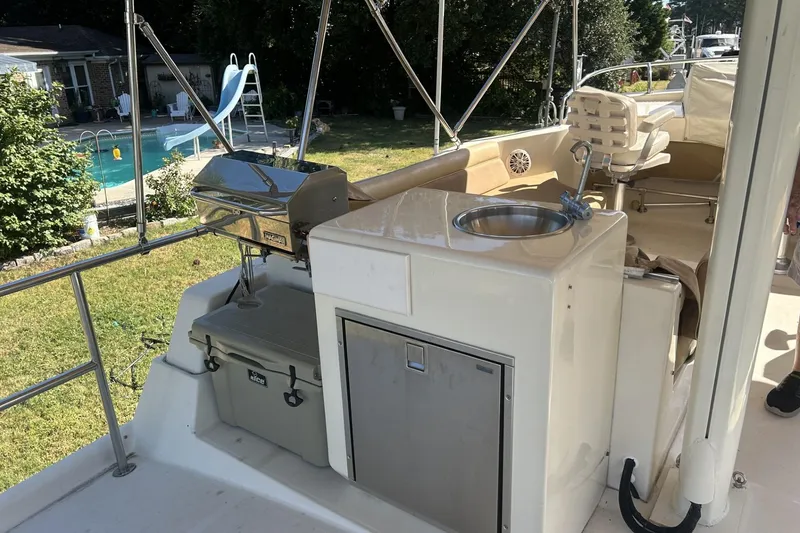 Slide: The Image of 2008 Mainship 34 Trawler deck with grill, sink, and seating area. - 21