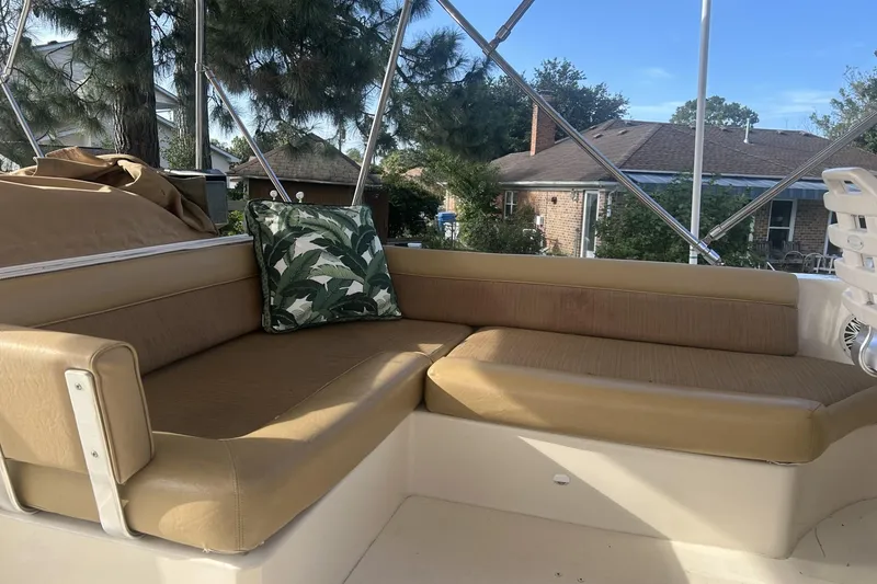 Slide: The Image of 2008 Mainship 34 Trawler seating area with tan cushions and a decorative pillow. - 25