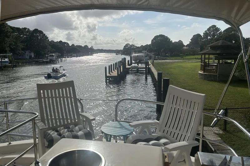 Slide: The Image of 2008 Mainship 34 Trawler on a scenic river with chairs and gazebo. - 26