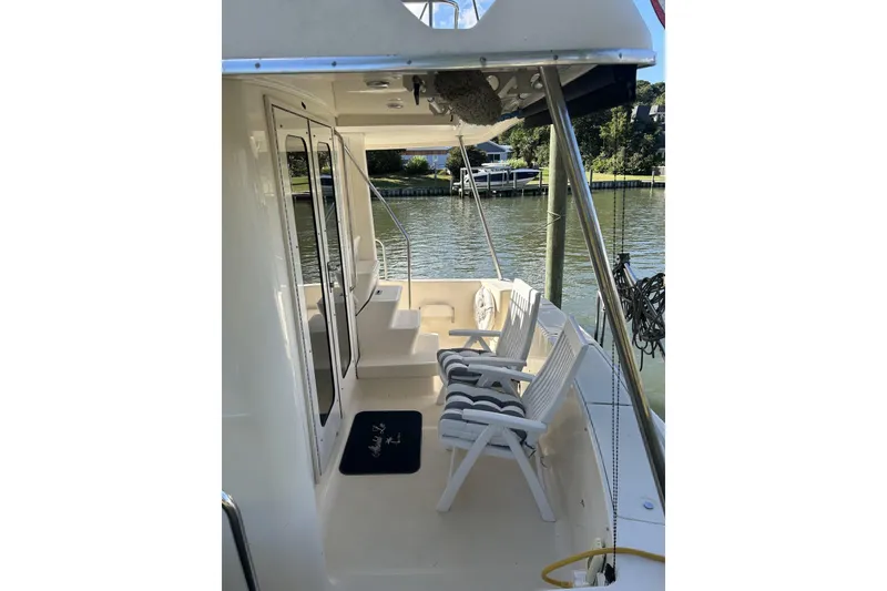 Slide: The Image of 2008 Mainship 34 Trawler deck with chairs, docked by calm waters. - 28