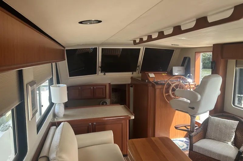 Slide: The Image of 2008 Mainship 34 Trawler interior with helm, seating, and wooden cabinetry. - 4