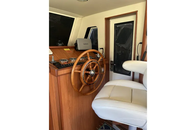 Slide: The Image of 2008 Mainship 34 Trawler helm with wooden wheel and white captain's chair. - 6
