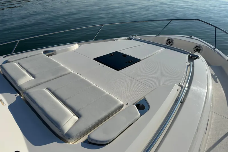 Slide: The Image of 2024 Pursuit OS 445 Offshore boat deck with cushioned seating, on calm water. - 15