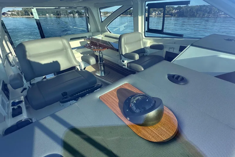 Slide: The Image of 2024 Pursuit OS 445 Offshore interior with seating and navigation compass. - 18