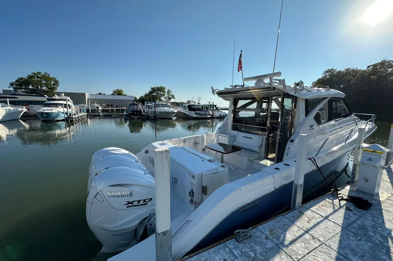 Slide: The Image of 2024 Pursuit OS 445 Offshore boat docked at marina with Yamaha engines. - 2