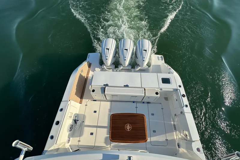 Slide: The Image of 2024 Pursuit OS 445 Offshore boat with triple engines on open water. - 21