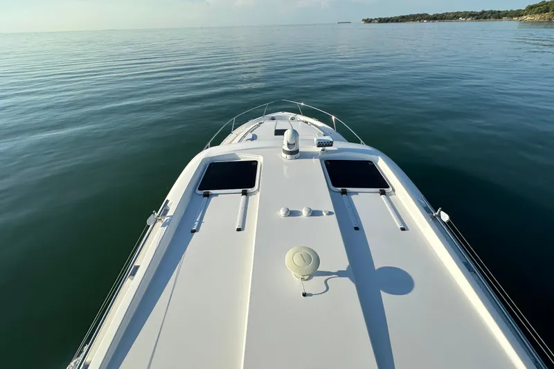 Slide: The Image of 2024 Pursuit OS 445 Offshore boat cruising on calm waters, top deck view. - 22