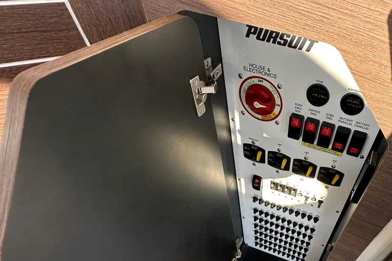 Slide: The Image of 2024 Pursuit OS 445 Offshore electrical panel with switches and controls. - 28