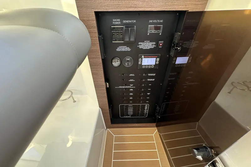 Slide: The Image of 2024 Pursuit OS 445 Offshore electrical panel with controls and gauges. - 29