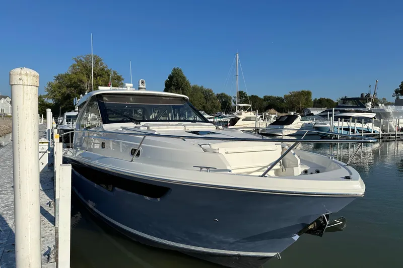 Slide: The Image of 2024 Pursuit OS 445 Offshore yacht docked in a marina under clear blue skies. - 3