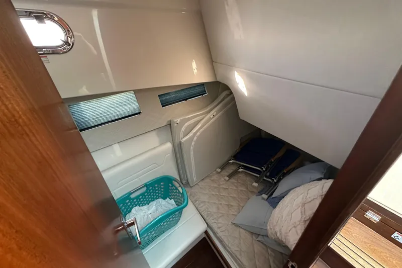 Slide: The Image of 2024 Pursuit OS 445 Offshore cabin interior with bedding and storage. - 36