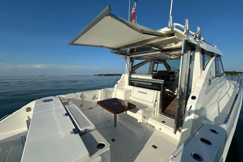 Slide: The Image of 2024 Pursuit OS 445 Offshore yacht with open deck and seating area on calm water. - 42