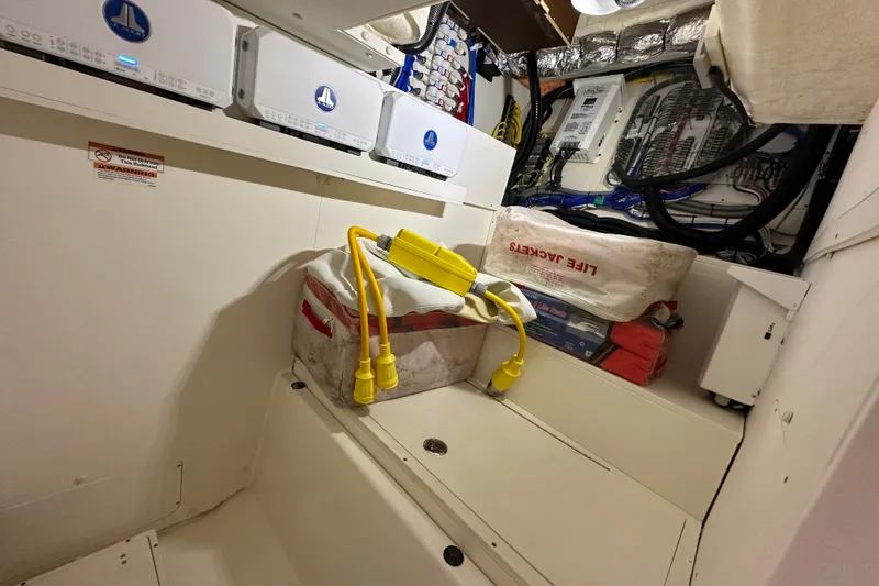 Slide: The Image of 2024 Pursuit OS 445 Offshore interior with life jackets and electrical equipment. - 45