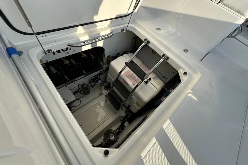 Slide: The Image of 2024 Pursuit OS 445 Offshore engine compartment with visible components and storage. - 47