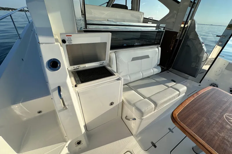 Slide: The Image of 2024 Pursuit OS 445 Offshore boat interior with seating and grill area. - 48