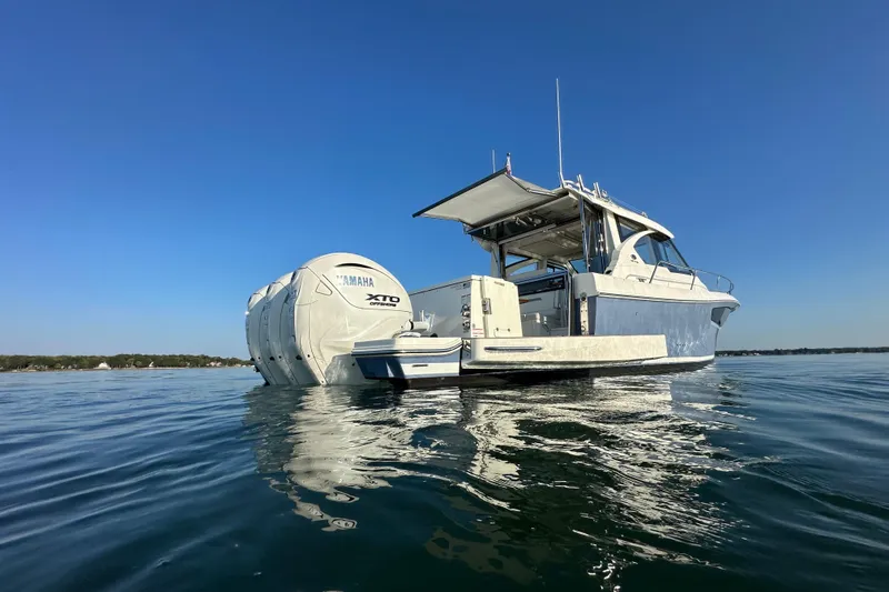 Slide: The Image of 2024 Pursuit OS 445 Offshore boat with Yamaha XTO engines on calm water. - 49