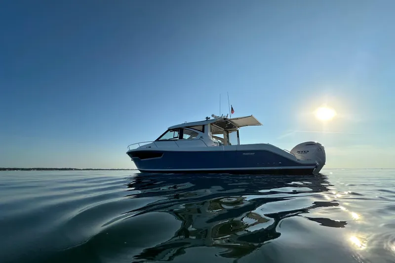 Slide: The Image of 2024 Pursuit OS 445 Offshore boat on calm water under a clear sky. - 53