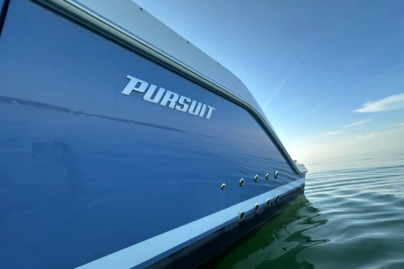 Slide: The Image of 2024 Pursuit OS 445 Offshore boat on calm water, side view. - 55