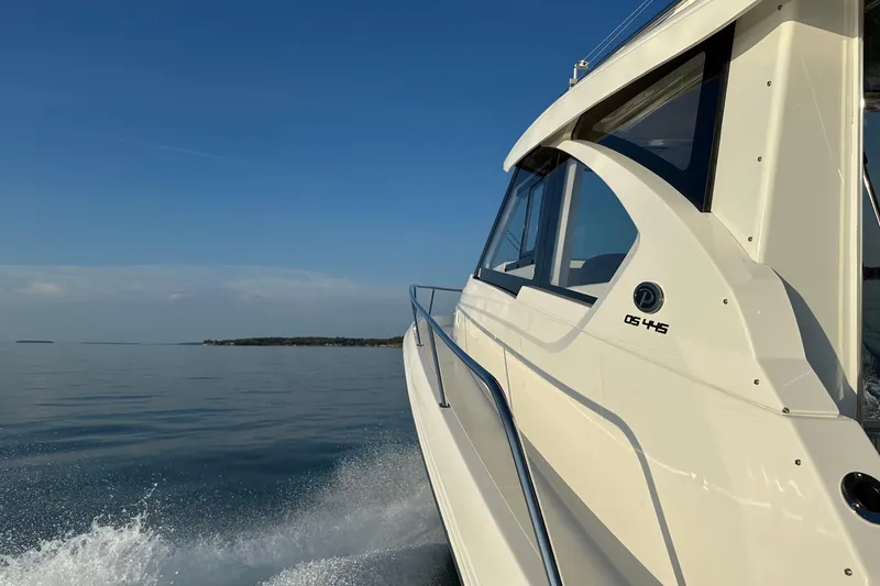 Slide: The Image of 2024 Pursuit OS 445 Offshore cruising on calm waters under clear blue sky. - 62