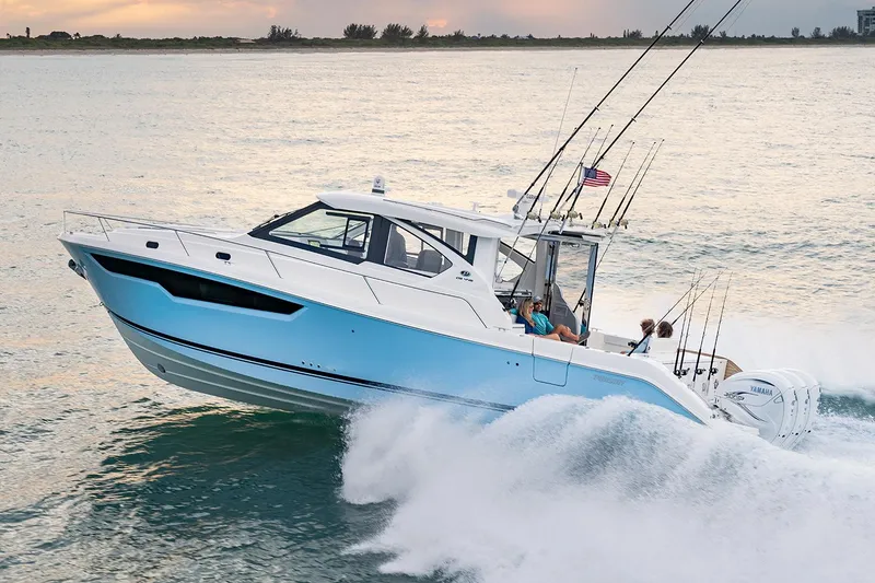 Slide: The Image of Manufacturer Provided Image: 2024 Pursuit OS 445 Offshore boat cruising on the water at sunset. - 70