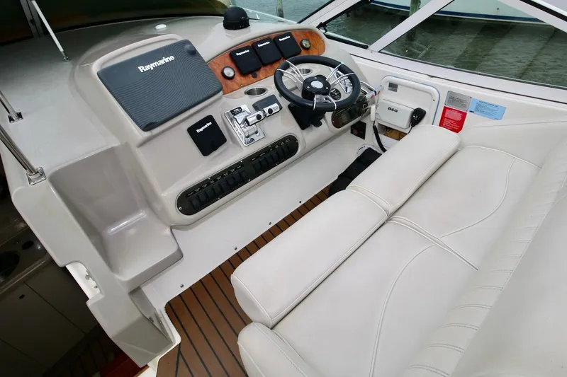 Slide: The Image of 2003 Cruisers Yachts 3470 Express helm with Raymarine electronics and white seating. - 11