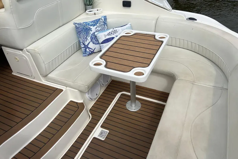Slide: The Image of 2003 Cruisers Yachts 3470 Express interior with cushioned seating and wooden table. - 17