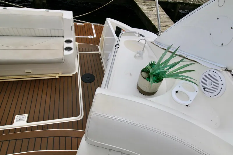 Slide: The Image of 2003 Cruisers Yachts 3470 Express interior with seating, wood flooring, and potted plant. - 18