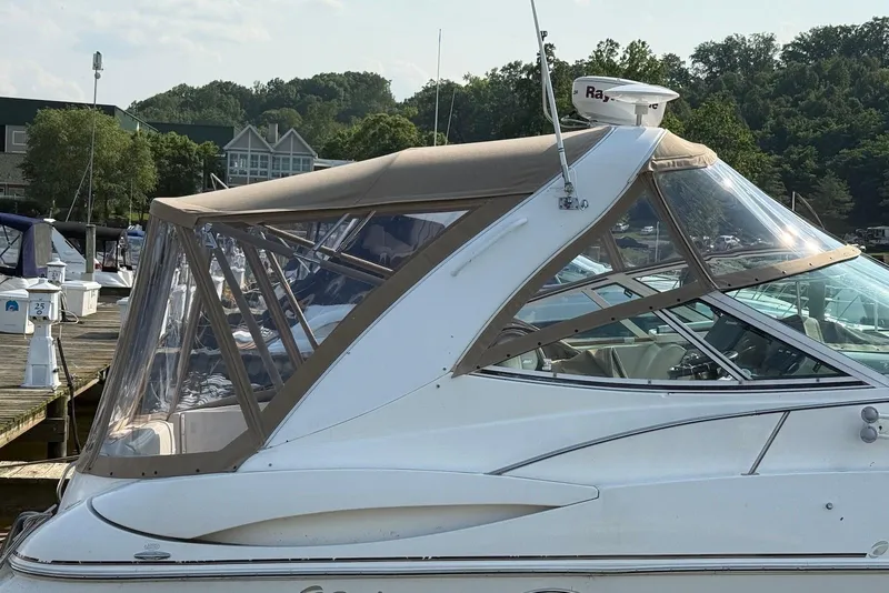 Slide: The Image of 2003 Cruisers Yachts 3470 Express docked with tan canopy and clear windows. - 20