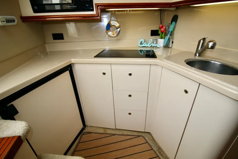 Slide: The Image of 2003 Cruisers Yachts 3470 Express kitchen with stove, sink, and storage cabinets. - 23