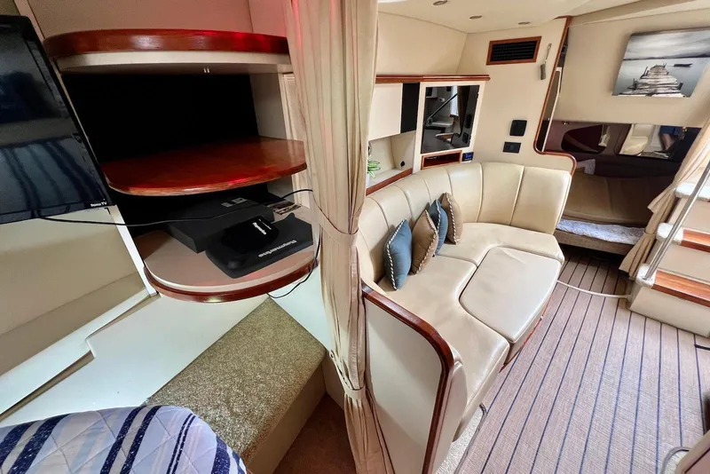 Slide: The Image of 2003 Cruisers Yachts 3470 Express interior with beige seating and wooden accents. - 26