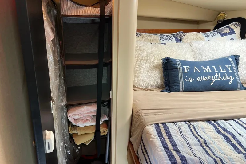 Slide: The Image of Cozy bedroom in 2003 Cruisers Yachts 3470 Express with decorative pillows and organized closet. - 30