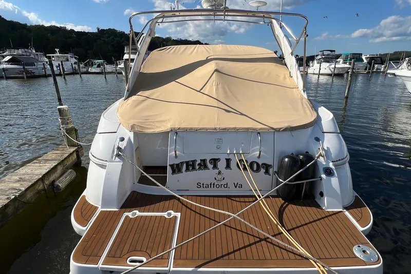 Slide: The Image of 2003 Cruisers Yachts 3470 Express docked at marina, rear view with cover. - 4