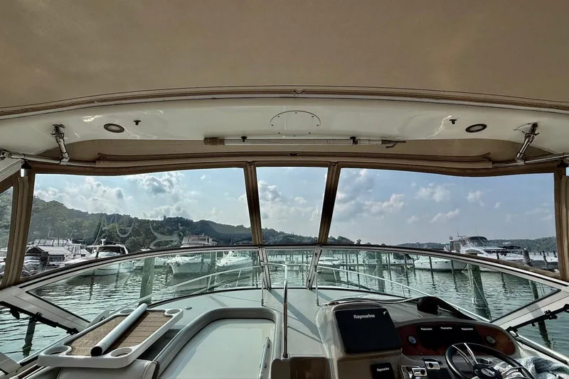 Slide: The Image of 2003 Cruisers Yachts 3470 Express cockpit view, overlooking marina and scenic landscape. - 6