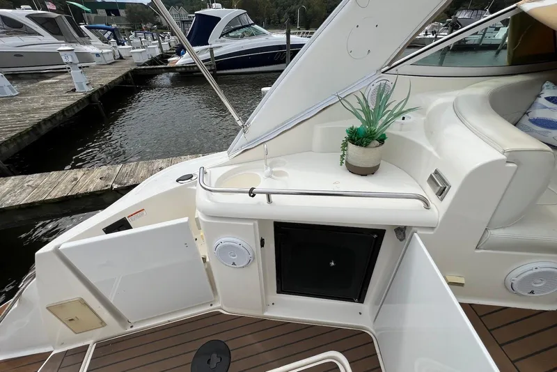 Slide: The Image of 2003 Cruisers Yachts 3470 Express interior with seating, plant decor, and dock view. - 10