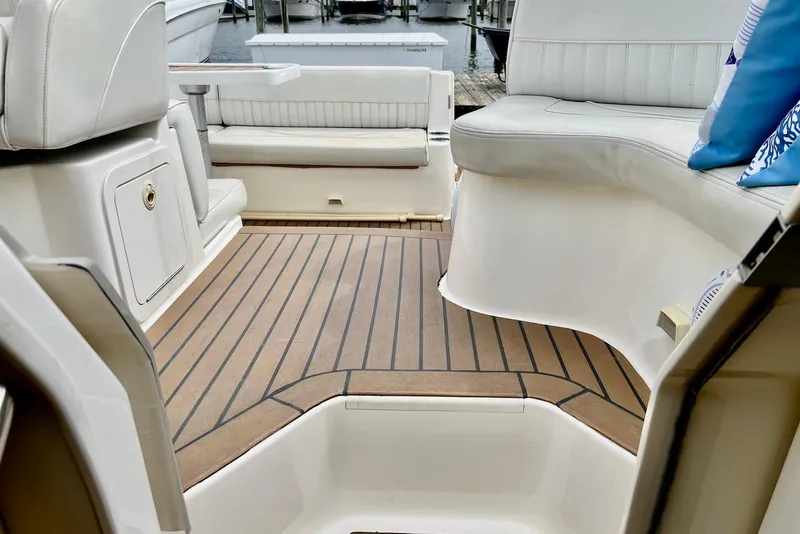 Slide: The Image of 2003 Cruisers Yachts 3470 Express interior with teak flooring and white seating. - 13