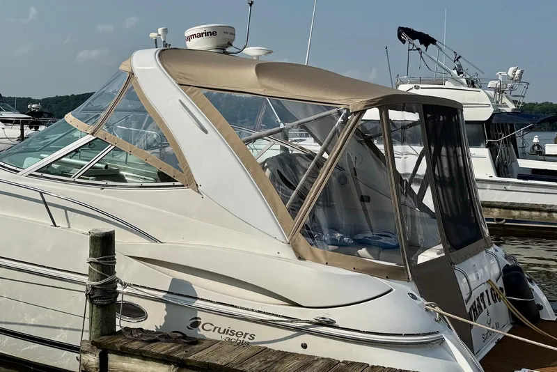 Slide: The Image of 2003 Cruisers Yachts 3470 Express docked at marina, featuring tan canopy and sleek design. - 19