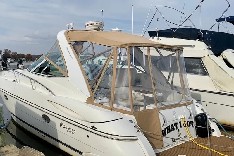 Slide: The Image of 2003 Cruisers Yachts 3470 Express docked, featuring a beige canopy and sleek design. - 2