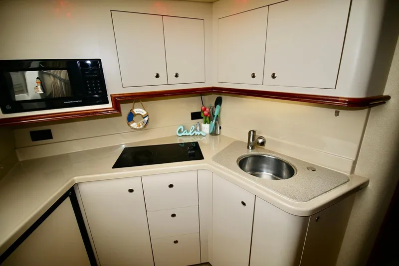 Slide: The Image of 2003 Cruisers Yachts 3470 Express kitchen with microwave, stovetop, and sink. - 24