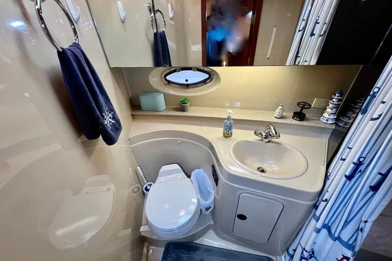 Slide: The Image of 2003 Cruisers Yachts 3470 Express bathroom with sink, toilet, and nautical decor. - 33