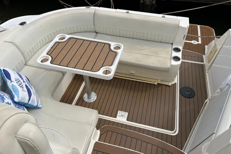 Slide: The Image of 2003 Cruisers Yachts 3470 Express interior with cushioned seating and wooden table. - 5