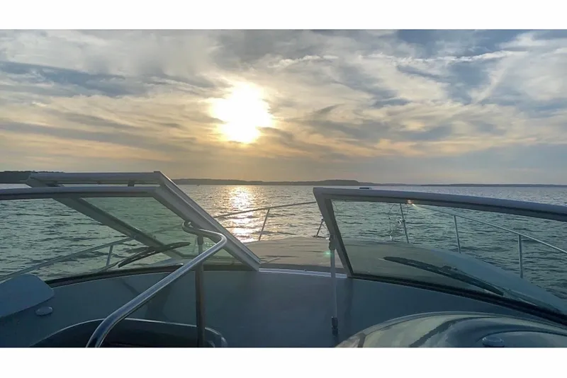 Slide: The Image of 2003 Cruisers Yachts 3470 Express on water at sunset, open deck view. - 8