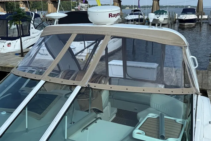 Slide: The Image of 2003 Cruisers Yachts 3470 Express docked, featuring a covered cockpit and Raymarine equipment. - 9