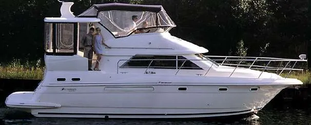 The Image of 1999 Cruisers Yachts 3750 Motoryacht docked at marina under clear blue sky. - 0