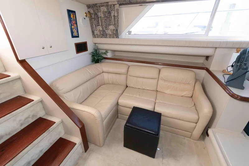 Slide: The Image of 1999 Cruisers Yachts 3750 Motoryacht interior with beige leather sofa and wooden stairs. - 9
